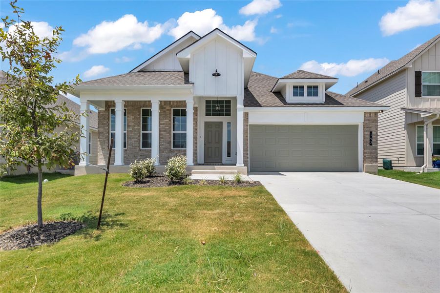 Modern inspired farmhouse with a porch, board and batten siding, roof with shingles, an attached garage, and concrete driveway Modern inspired farmhouse with a porch, board and batten siding, roof with shingles, an attached garage, and concrete driveway