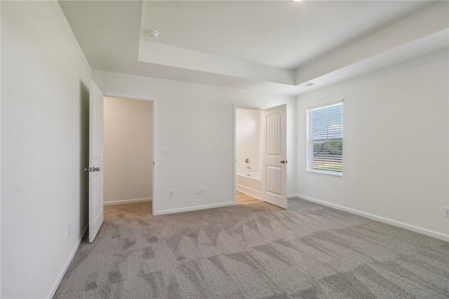 This primary bedroom features plush carpeting and This primary bedroom features plush carpeting and