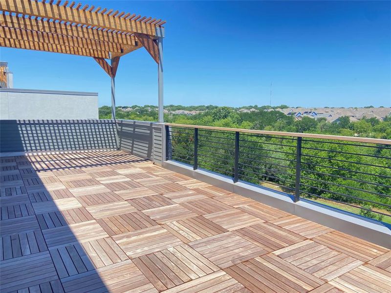 Expansive rooftop terrace featuring wood-finish deck tiles, a slatted pergola, and a sleek cable railing with fabulous views. (construction photos - professional photos upon completion) Expansive rooftop terrace featuring wood-finish deck tiles, a slatted pergola, and a sleek cable railing with fabulous views. (construction photos - professional photos upon completion)
