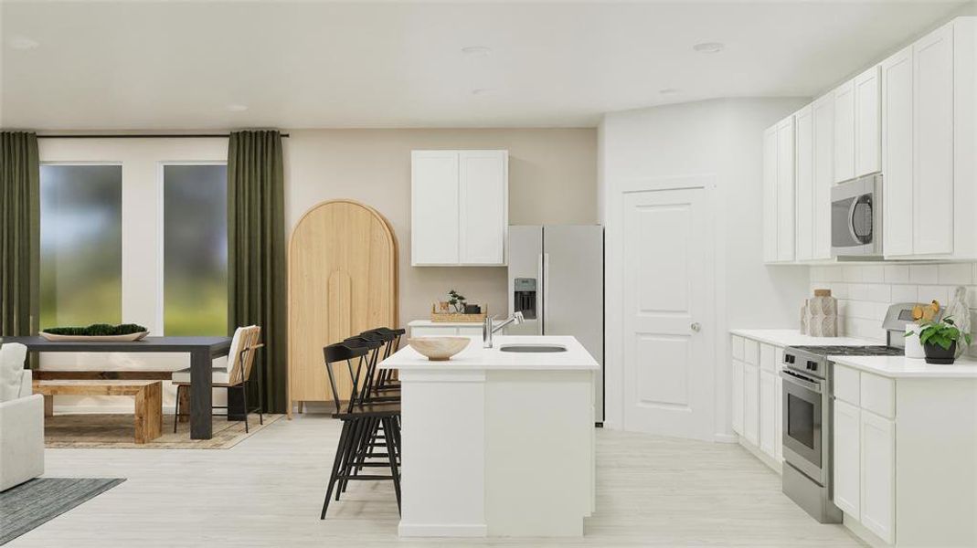 Kitchen featuring appliances with stainless steel finishes, white cabinets, decorative backsplash, a center island with sink, and a breakfast bar