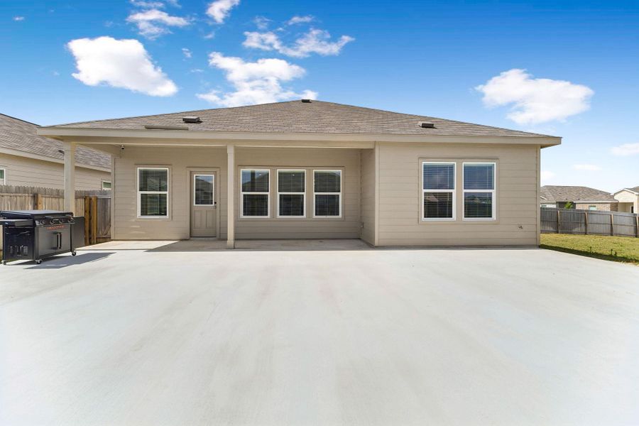 A spacious concrete patio awaits outdoor enjoyment at the rear of this inviting residence.