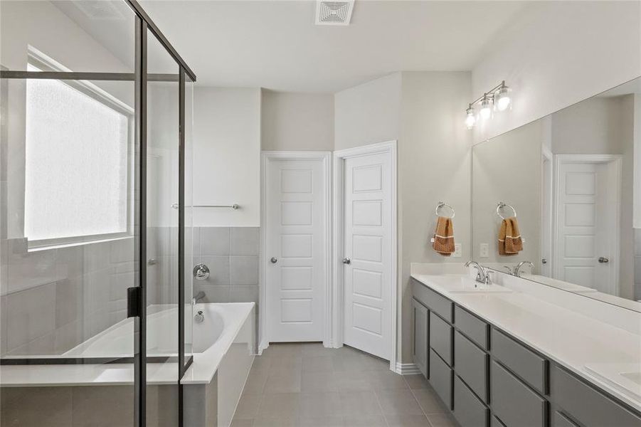 Bathroom featuring dual vanity, independent shower and bath, and tile patterned floors