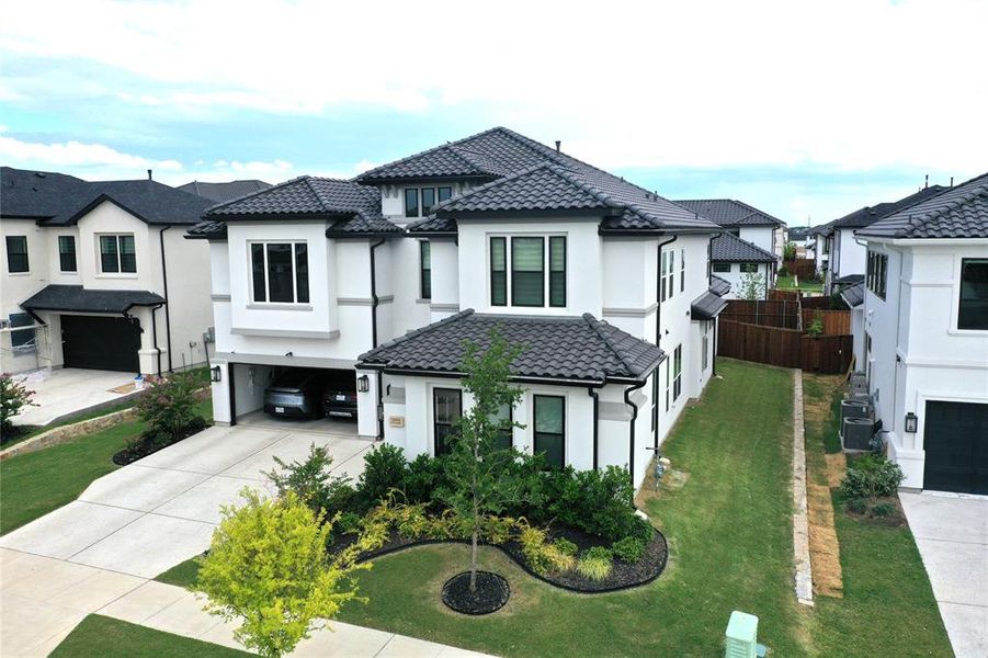 View of front of property with stucco siding, driveway, and a residential view
