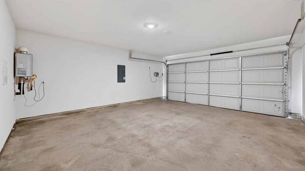 Spacious garage with a concrete floor, bright white walls, and a recessed ceiling light