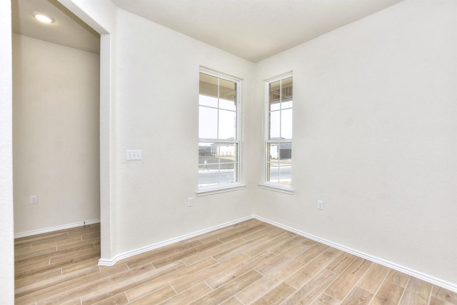 Spare room with baseboards and wood finish floors