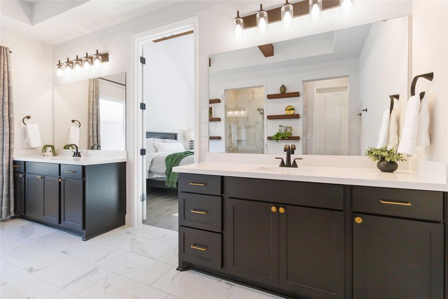 Bathroom featuring two vanities, a stall shower, connected bathroom, and light marble finish floors Bathroom featuring two vanities, a stall shower, connected bathroom, and light marble finish floors