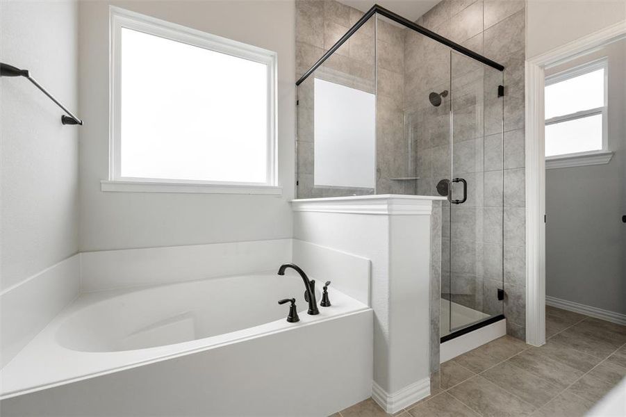 Bathroom with a garden tub, a stall shower, and tile patterned flooring Bathroom with a garden tub, a stall shower, and tile patterned flooring