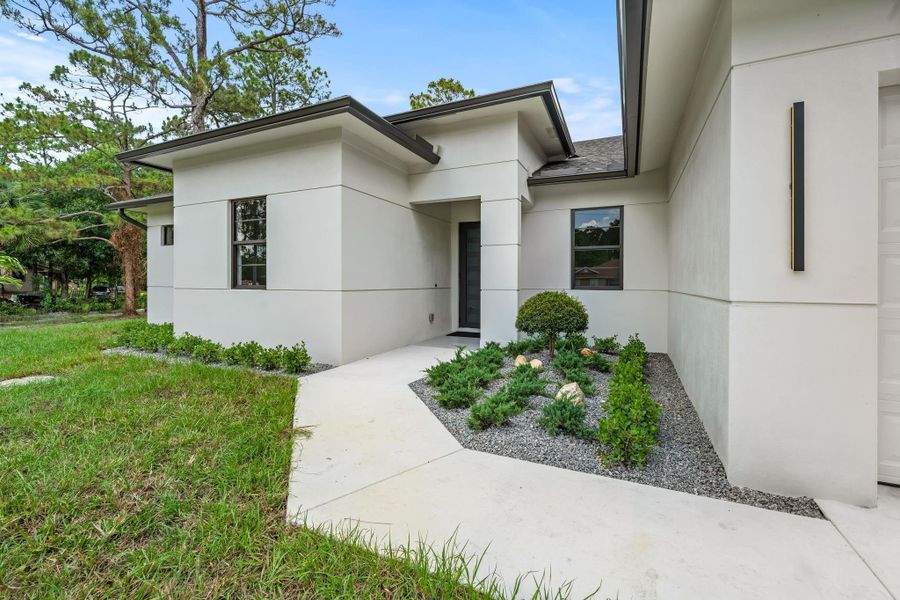Front exterior of a new home in , Loxahatchee, FL, highlighting curb appeal (Image 1). Front exterior of a new home in , Loxahatchee, FL, highlighting curb appeal (Image 1).