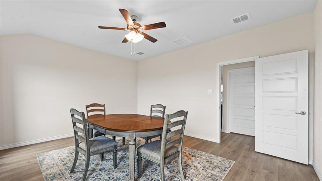 Dining space featuring ceiling fan, light wood-type flooring, and lofted ceiling Dining space featuring ceiling fan, light wood-type flooring, and lofted ceiling