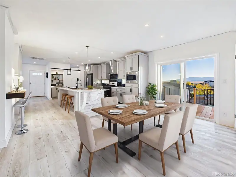 Virtually staged dining area showing seamless flow to the kitchen and deck with lake views. Virtually staged dining area showing seamless flow to the kitchen and deck with lake views.