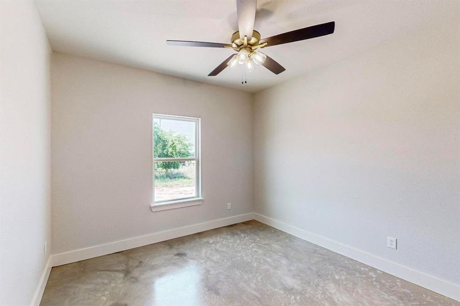 Spare room featuring concrete flooring and ceiling fan