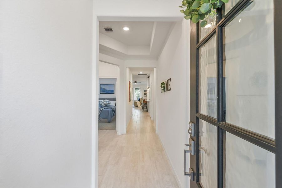 The front door opens to the foyer with tray ceilings and beautiful light wood look tile, which continues through all common areas!
