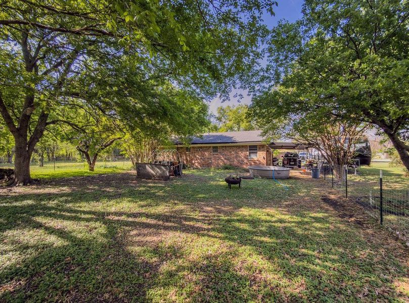 Fenced backyard featuring a hot tub