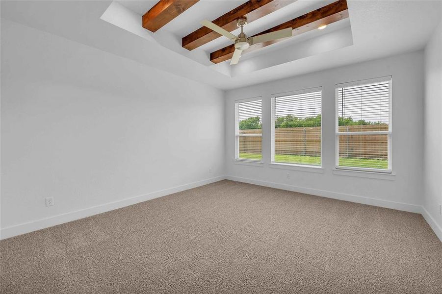 Spare room with baseboards, ceiling fan, beamed ceiling, and light colored carpet Spare room with baseboards, ceiling fan, beamed ceiling, and light colored carpet