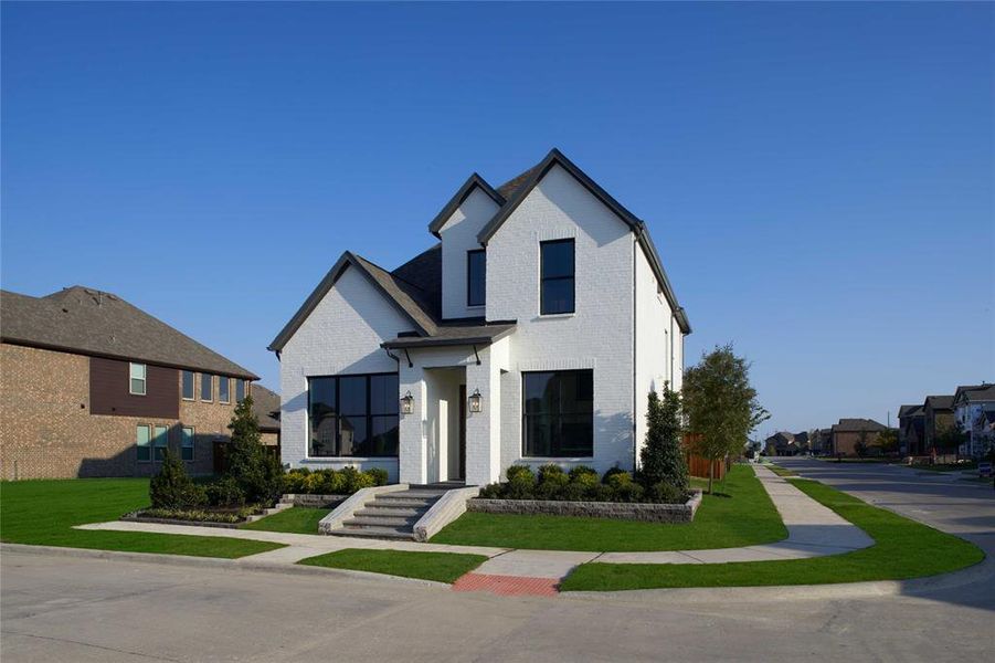 Modern farmhouse with brick siding and a front lawn