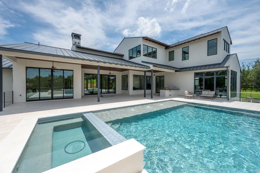 An inviting backyard oasis offers a sparkling pool and spa with ample outdoor living space.
