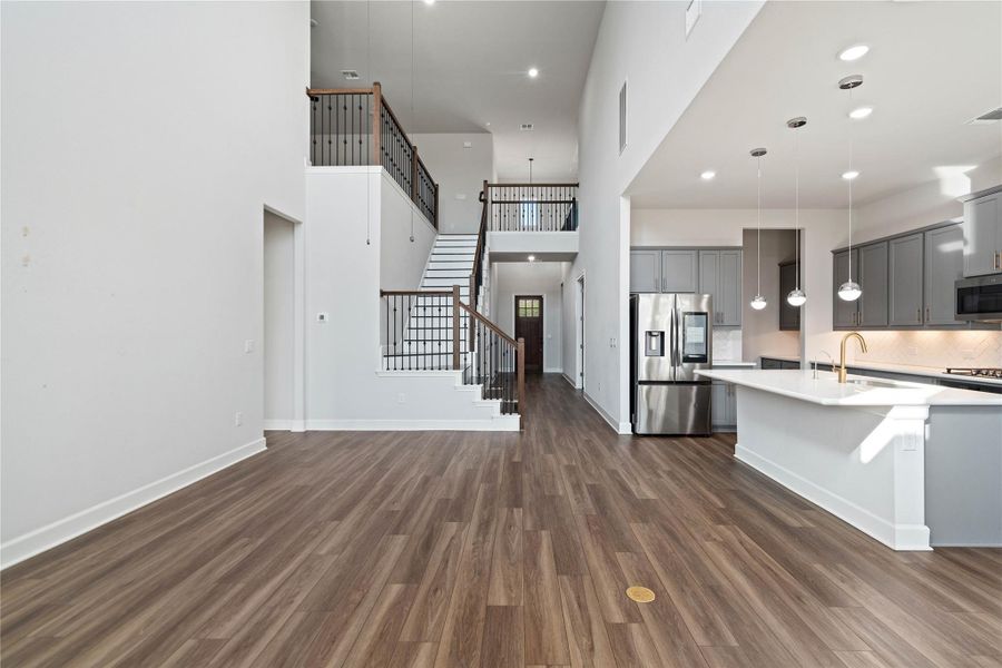 Dramatic soaring ceilings and rich plank flooring define this striking open-concept layout.