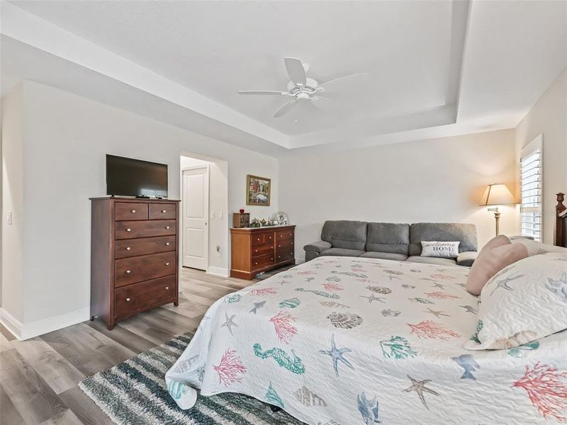 Primary Bedroom with Sliders leading out to the Lanai, Plantation Shutters, And coffered ceiling