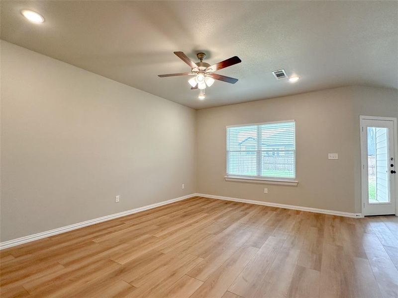 Empty room with a wealth of natural light, light hardwood / wood-style flooring, and ceiling fan