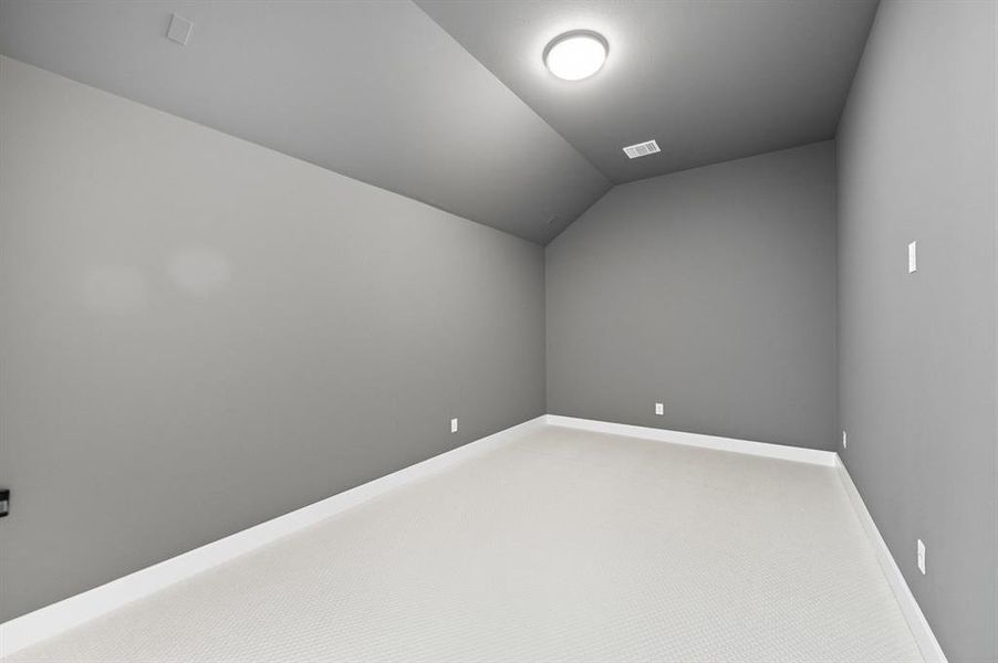 Additional living space with vaulted ceiling and carpet floors