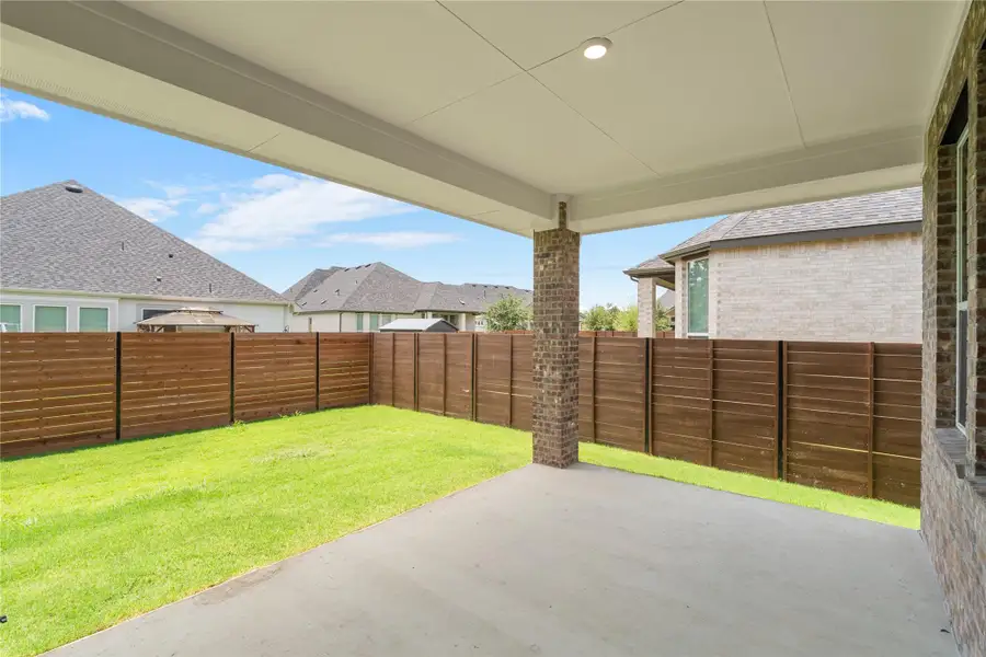 A spacious covered patio overlooks a private, fenced backyard, ideal for outdoor gatherings. A spacious covered patio overlooks a private, fenced backyard, ideal for outdoor gatherings.