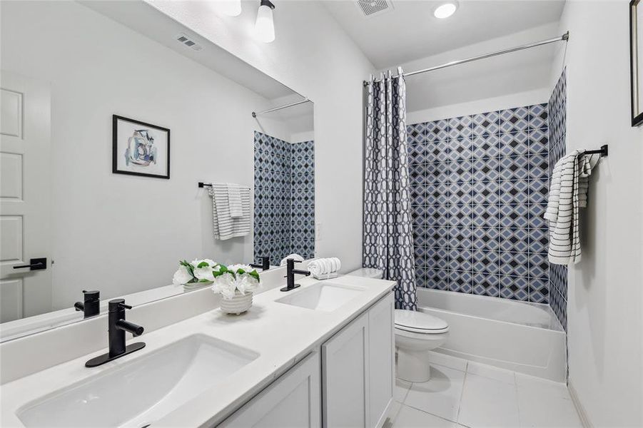 Full bathroom featuring shower / tub combo, vanity, tile patterned floors, and toilet