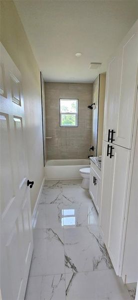 hall off kitchen area with tiled tubshower combo, granite counters, lien closet
