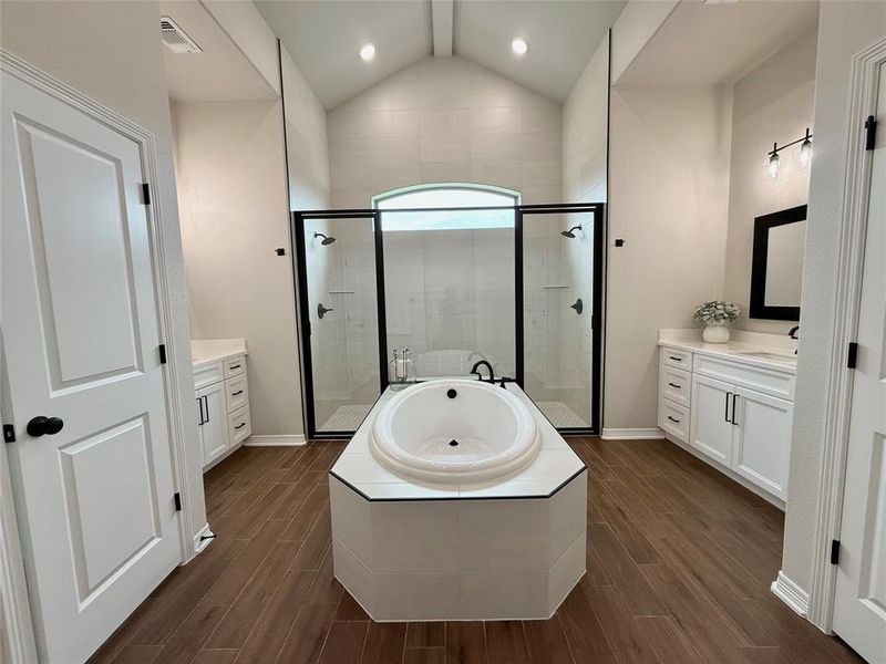 Bathroom featuring vanity, a stall shower, a garden tub, wood finish floors, and recessed lighting Bathroom featuring vanity, a stall shower, a garden tub, wood finish floors, and recessed lighting