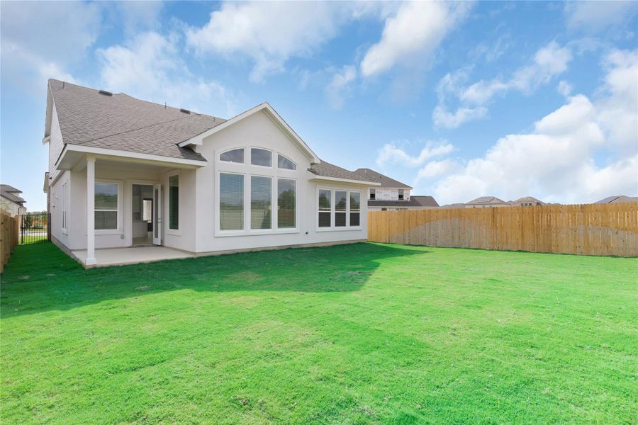 Rear view of house with roof with shingles, a fenced backyard, a patio, and stucco siding