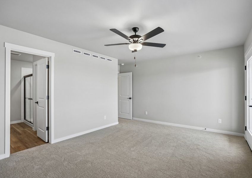 The master bedroom is spacious with a ceiling fan.