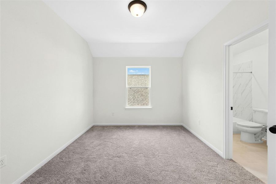 Unfurnished bedroom featuring light colored carpet and ensuite bath Unfurnished bedroom featuring light colored carpet and ensuite bath