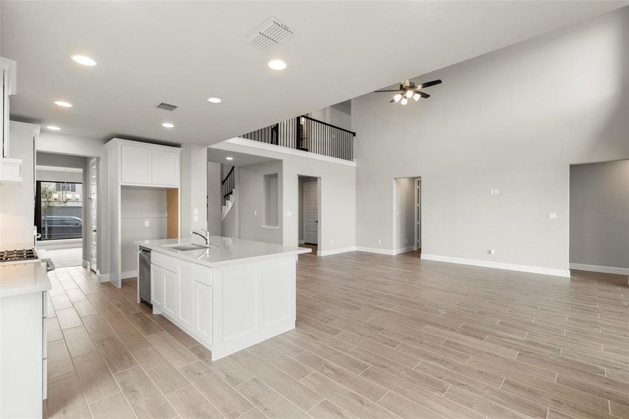 Gorgeous Quartz Countertops, an Island with a Sink, Dishwasher, and Modern Lighting.