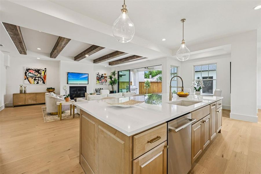Gourmet kitchen island with white countertop, integrated sink, and stainless steel dishwasher