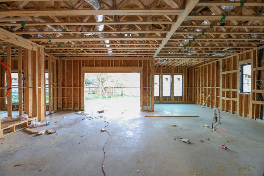 *Construction Progress Photo taken 11/20/25* Wide view of the Family Room entrance. Gourmet Kitchen & Breakfast area to the right w/ wall of sliding windows that lead to over sized covered patio & Summer Kitchen. Home Features advanced insulation, high-quality Andersen windows, and high-efficiency systems to enhance comfort and reduce energy costs