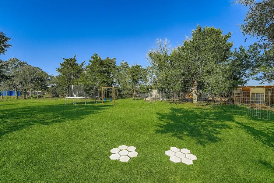 View of yard featuring a trampoline and a playground View of yard featuring a trampoline and a playground