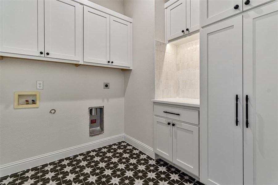 Washroom with hookup for an electric dryer, washer hookup, hookup for a gas dryer, and cabinets