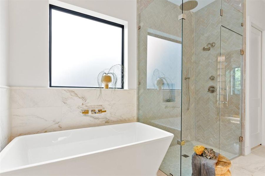 Full bath featuring a freestanding tub, a shower stall, tile walls, and marble finish flooring