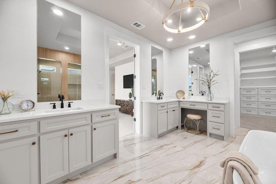 Bathroom featuring a stall shower, two vanities, light marble finish flooring, a chandelier, and a freestanding tub Bathroom featuring a stall shower, two vanities, light marble finish flooring, a chandelier, and a freestanding tub