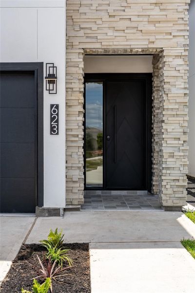 A grand stone entrance is anchored by a heavy-duty cast-iron front door with toughened glass sidelights—welcoming you into the heart of luxury