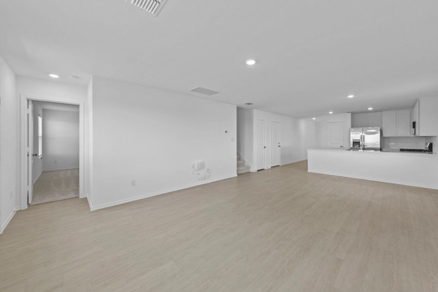 Unfurnished living room with recessed lighting, light wood-type flooring, and stairway