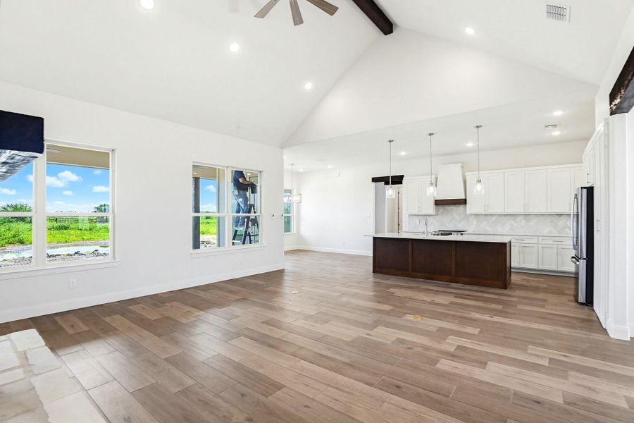 A spacious, open-concept living area with vaulted ceilings seamlessly connects to a modern kitchen.