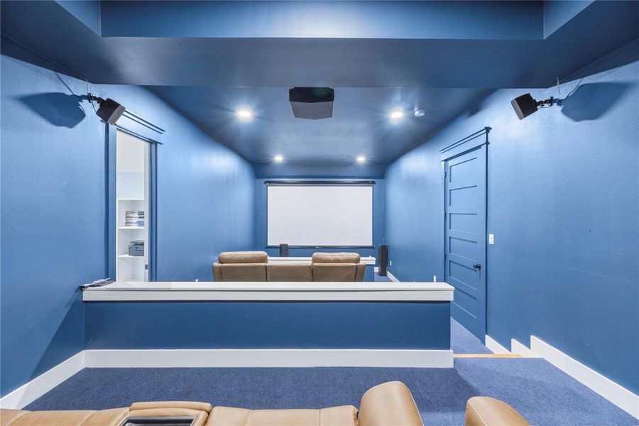 Immersive media room designed for cinematic experiences with tiered seating and dedicated surround sound setup.