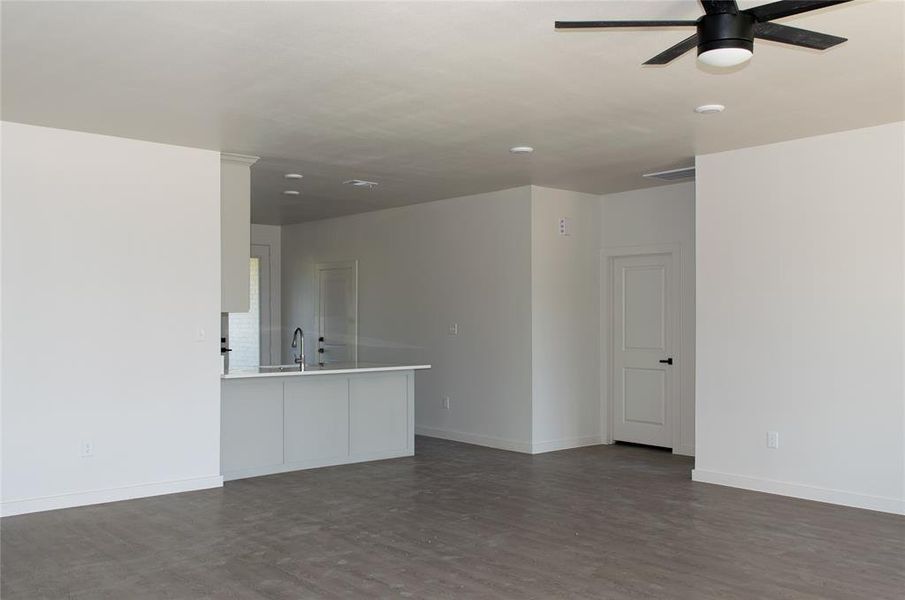 Spare room with dark wood-style floors and ceiling fan Spare room with dark wood-style floors and ceiling fan