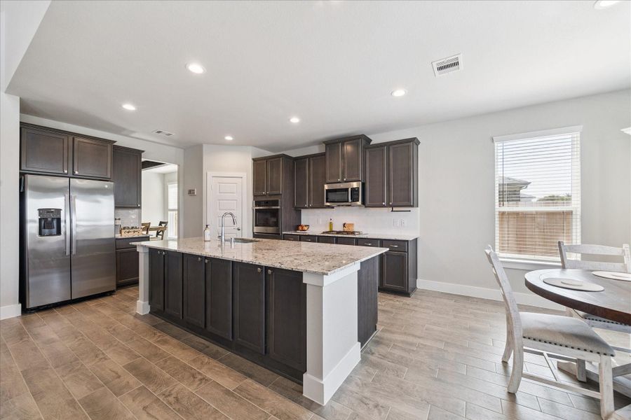 Modern kitchen with granite island, stainless steel appliances, and ample cabinet space. Modern kitchen with granite island, stainless steel appliances, and ample cabinet space.