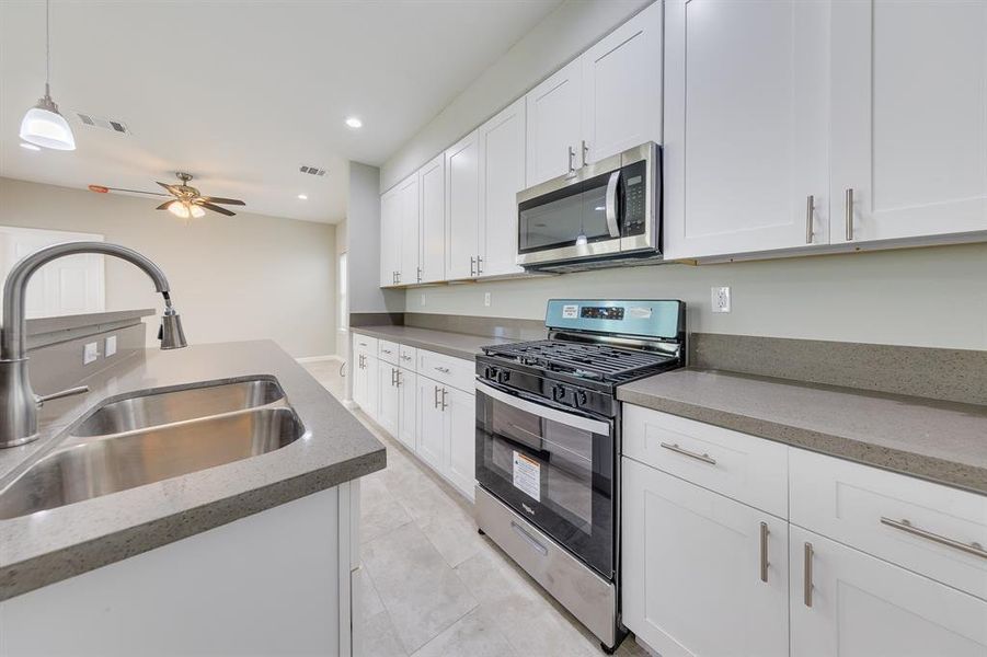 A closer look into the kitchen reveals sleek stainless steel appliances, a convenient double sink, and an impressive amount of storage space. Perfectly sized for those who enjoy whipping up quick meals or crafting cocktails, this kitchen combines functionality with style. Its efficient layout makes meal prep a breeze, while still offering plenty of room for entertaining.