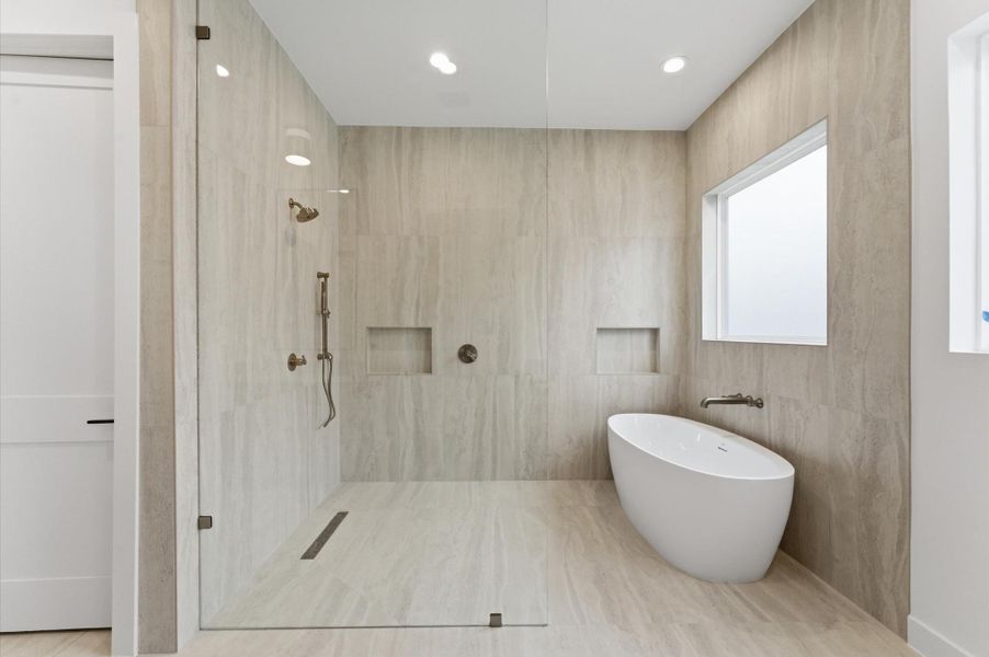 The primary bathroom features a large shower and stand alone soaking tub.