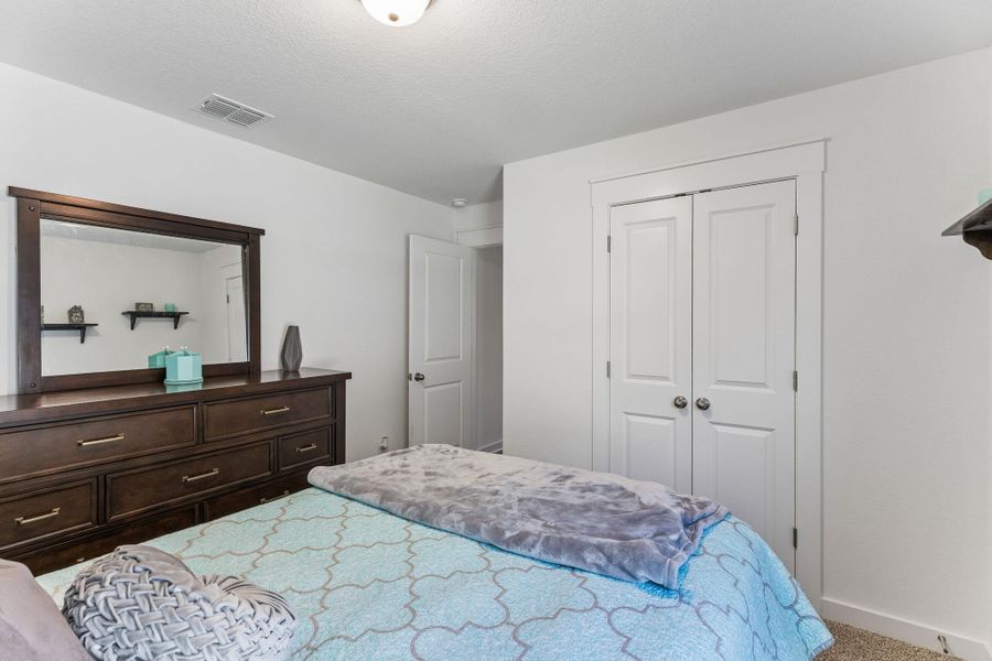 Bedroom featuring neutral wall paint, white trim, and light-colored carpeting