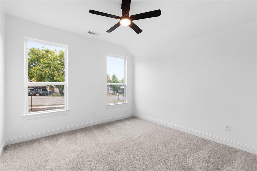 Spare room with carpet flooring, lofted ceiling, and ceiling fan