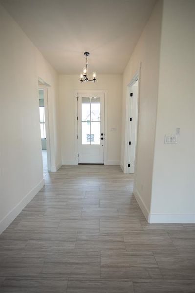 Doorway with a chandelier and wood finished floors Doorway with a chandelier and wood finished floors