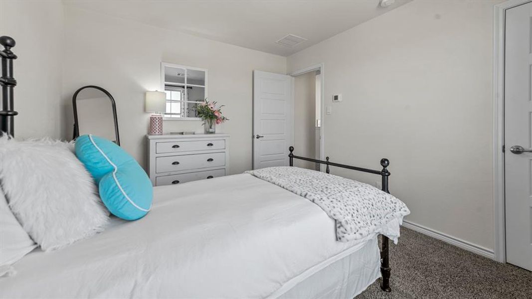 Wall-to-wall carpeting in a neutral tone complements the light-colored walls